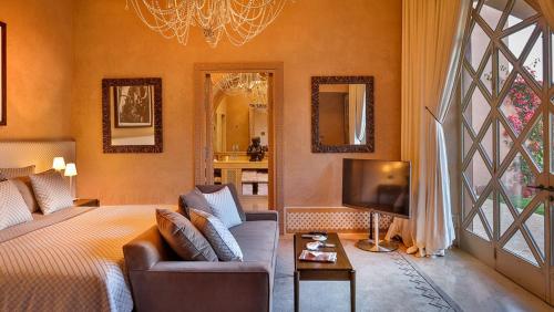 - une chambre avec un lit, un canapé et une télévision dans l'établissement Moon Light wolfie, à Marrakech