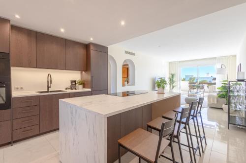 een keuken met een groot eiland met barkrukken bij Top floor spacious apartment with sea views in Costalita in Estepona