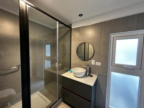 a bathroom with a shower and a sink and a mirror at Starigrad in Ushuaia