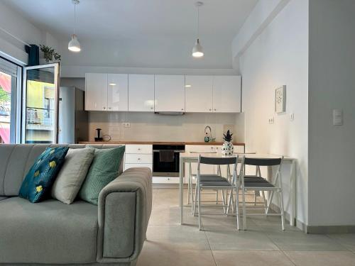a living room with a couch and a table and a kitchen at P&P - Brand new chic apartments in Athens
