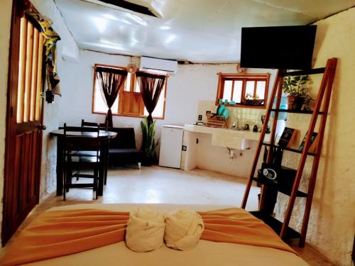 a room with a bed and a table and a kitchen at Arte Sano Hotel Only Adults - Near Beach in Holbox Island