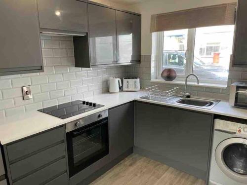 a kitchen with a sink and a dishwasher at Stylish Property in Nuneaton in Nuneaton