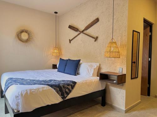 a bedroom with a large bed with blue pillows at Xaman - Boutique Studios in Cancún