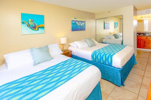 a hotel room with two beds and a mirror at Mountain View Condo Near Beach with Free Parking! in Honolulu