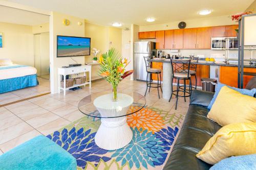 a living room with a couch and a table and a kitchen at Mountain View Condo Near Beach with Free Parking! in Honolulu
