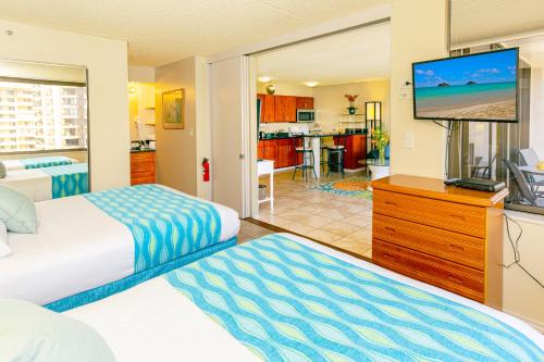 a bedroom with two beds and a flat screen tv at Mountain View Condo Near Beach with Free Parking! in Honolulu