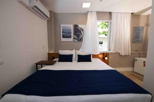 a bedroom with a large bed and a window at Leblon Design Hotel in Rio de Janeiro