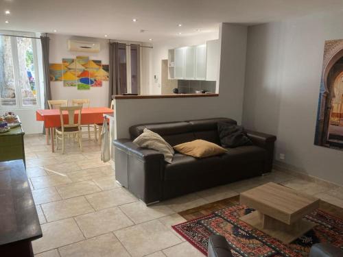 Appartement «Marrakech » à Avignon في أفينيون: غرفة معيشة مع أريكة سوداء وطاولة