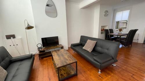 a living room with a couch and a table at A lovely Three bedroom house in Windsor in Windsor