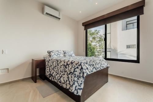 ein Schlafzimmer mit einem Bett und einem großen Fenster in der Unterkunft Cenote Korima - Relax in Paradise - Stunning House with Pool in Cancún