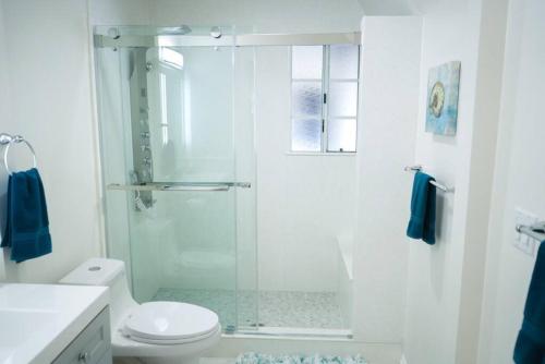 La salle de bains blanche est pourvue d'une douche et de toilettes. dans l'établissement Quiet, Relaxing and Close to most Amenities, à La Verne