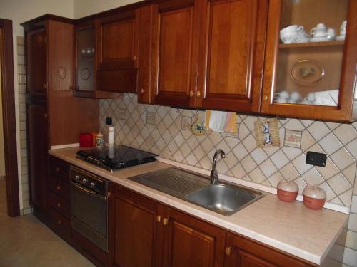 a kitchen with wooden cabinets and a sink at Il Glicine in Capo dʼOrlando