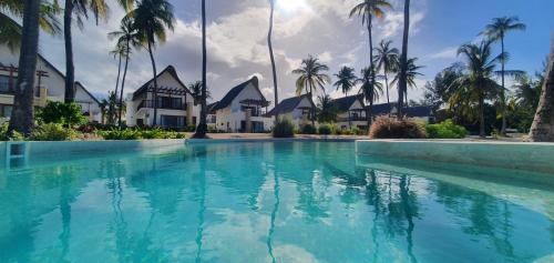 a pool in front of a resort with palm trees at Ocean View Villa with pool, Zanzibar in Pingwe