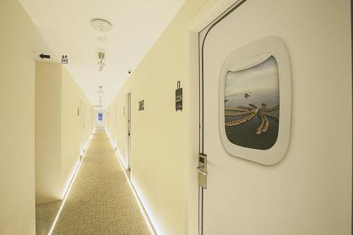 an empty hallway with a mirror and a window at Sri Langit Hotel KLIA, KLIA 2 & F1 in Sepang