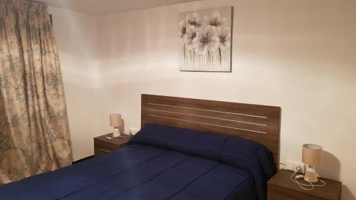 a bedroom with a bed with a blue comforter at Can Marti in Alfara de Carles