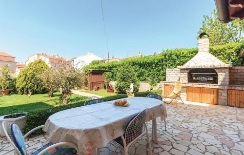 a table and chairs on a patio with a fireplace at Apartment Zdravko in Štinjan