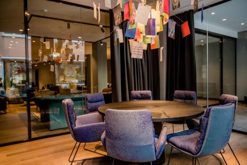 a conference room with a wooden table and purple chairs at Motel One Ulm in Ulm