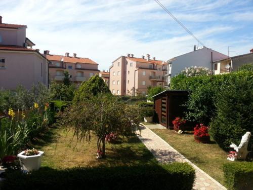 a garden with trees and plants in a city at Apartment Zdravko in Štinjan