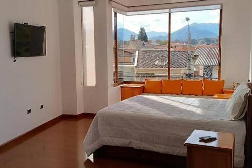 1 dormitorio con cama y ventana grande en Cuenca -Sucre Suites Modern Lux, en Cuenca