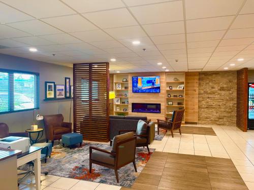 a lobby with a waiting room with chairs and a tv at Country Inn & Suites by Radisson Rehoboth Beach - Dewey in Rehoboth Beach