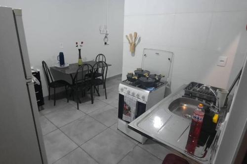 kuchnia z kuchenką i stołem z krzesłami w obiekcie North Park 388 w mieście Campo Grande