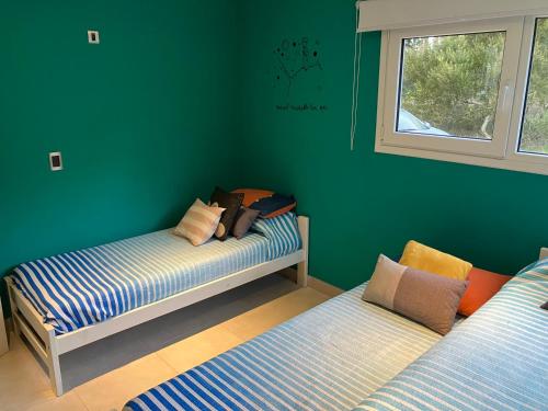 Grünes Zimmer mit 2 Betten und einem Fenster in der Unterkunft Losgumitas 2 in Mar de las Pampas