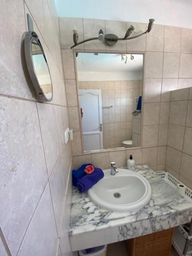 uma casa de banho com um lavatório e um espelho em Bungalow Rey Carlos em Puerto del Carmen