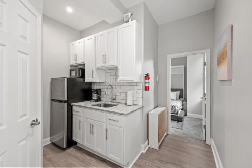 a kitchen with white cabinets and a black refrigerator at Lovely Renovated 1Bdrm 1Bath Getaway in Ocean City