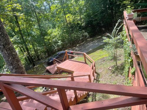 a wooden deck with a bench and a car parked on a bridge at Smokey Mountain Cabin in Murphy
