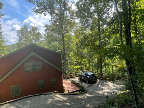 an aerial view of a house and a truck parked next to a forest at Smokey Mountain Cabin in Murphy
