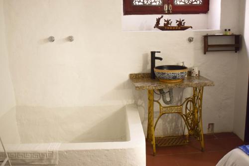 a bathroom with a tub and a table with a sink at HOTEL CHORRO DE LUZ in Bogotá