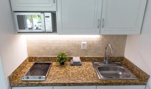 a kitchen counter with a sink and a microwave at 1209 Beautiful Beach Studio on Hotel Zone in Cancún