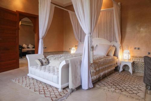 a bedroom with a white bed with a canopy at Villa Taj Sofia & Spa in Marrakesh