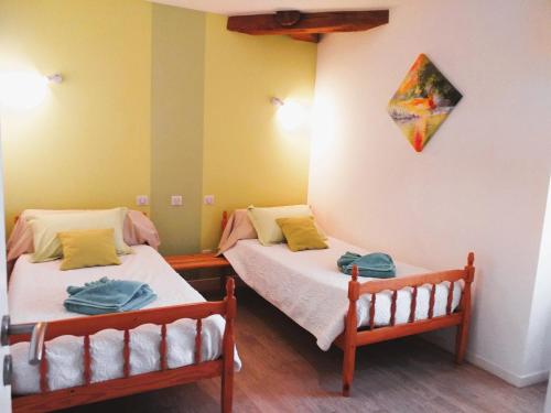 2 Betten in einem Zimmer mit gelben Wänden in der Unterkunft Gîte Le Bernard, 6 pièces, 10 personnes - FR-1-426-164 in Le Bernard