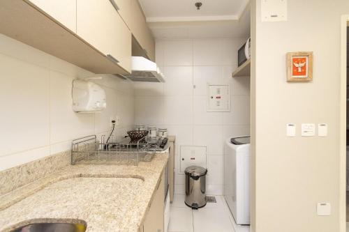a small white kitchen with two sinks in a room at Edifício Metropolitan Barcelona - Jardim Goias - MBC in Goiânia