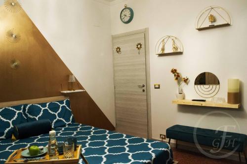 Un dormitorio con una cama azul y un reloj en la pared en Fenty Guest House en Roma
