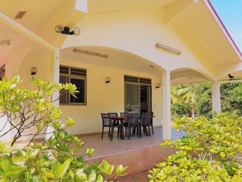 a patio with a table and chairs on a house at HUAHINE - Tipanier House in Haapu