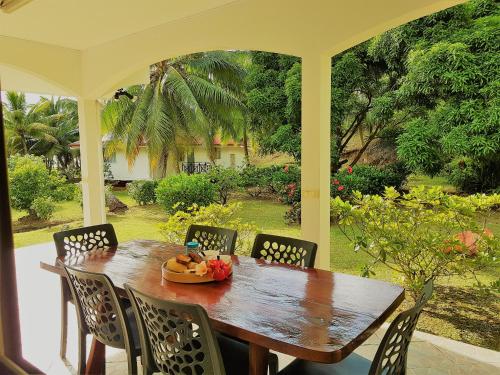 a wooden table and chairs on a porch at HUAHINE - Tipanier House in Haapu