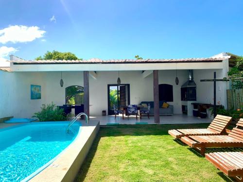 un patio trasero con piscina y una casa en Casa praia do espelho, Outeiro das Brisas en Praia do Espelho