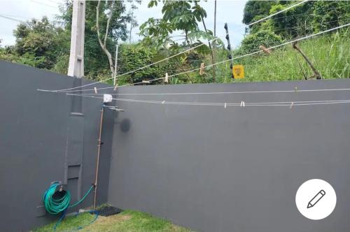 a fence with a hose hooked up to a wall at Casa de Praia da Lara in Piúma