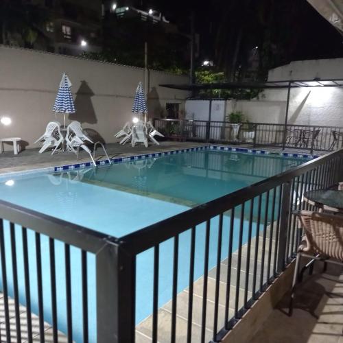 a swimming pool at night with christmas decorations at Pousada Parque Suites - Estacionamento e Piscina in Guarujá