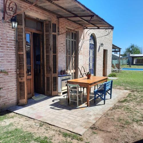 a patio with a wooden table and blue chairs at Inocencia Faez in Roldán