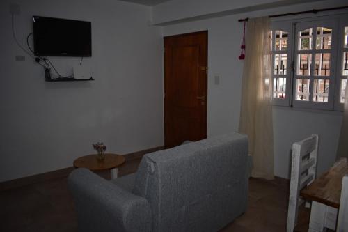 ein Wohnzimmer mit einem Sofa und einem TV in der Unterkunft Ukiyo Apart in San Salvador de Jujuy