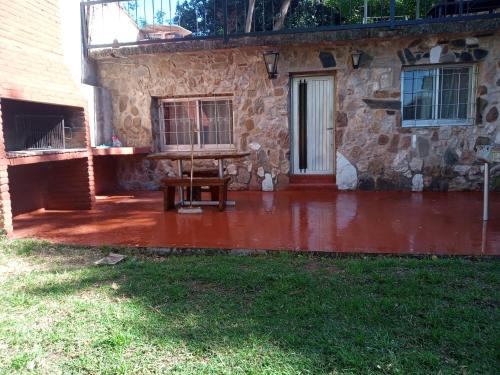 a patio with a wooden table in front of a building at Depto Cura Gaucho in Mina Clavero