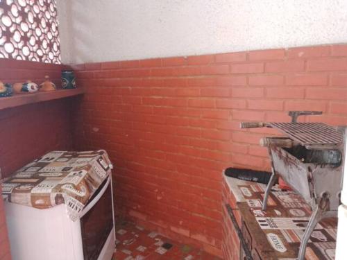 a room with a brick wall and a stove at Cantinho da Vovó Regina in Miguel Pereira