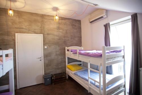 a room with two bunk beds and a window at Hostel Fair and Square in Belgrade