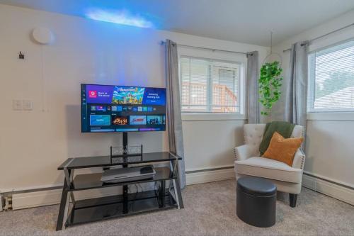 - un salon avec une télévision à écran plat et une chaise dans l'établissement Executive Apartment in Fairbanks, à Fairbanks