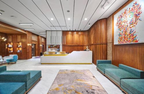 a lobby with blue couches and a reception desk at The Alana Hotel Malang in Malang