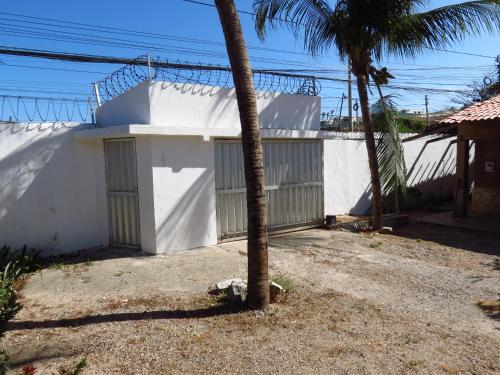 um edifício branco com uma palmeira em frente em Morada dos Ventos em Fortaleza