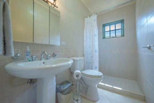 a white bathroom with a sink and a toilet at Palma Real 28 in Noord